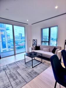 ein Wohnzimmer mit Sofa und Tisch in der Unterkunft Posh 2 bedroom apartment with a Gym in South Norwood