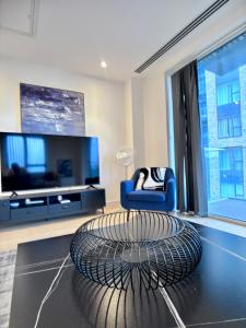 ein Wohnzimmer mit einem TV und einem blauen Stuhl in der Unterkunft Posh 2 bedroom apartment with a Gym in South Norwood + 23 Fotos