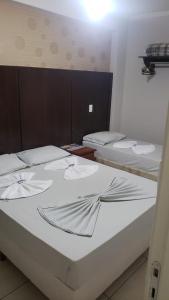 a room with three beds in a room at Princesa do Vale Hotel in Aparecida