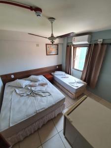 a room with two beds and a window at Princesa do Vale Hotel in Aparecida