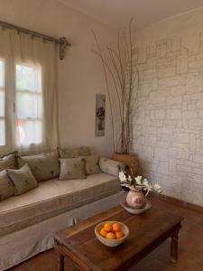 a living room with a couch and a table with a bowl of oranges at AMPELIA KYTHIRA in Livadi