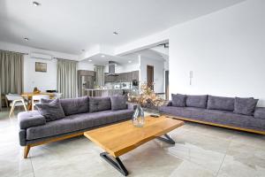 a living room with two couches and a table at Olymp Luxury Villa D - Luxury Escape with Direct Beach Access and Unique Sunsets in Paphos
