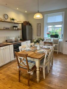 a kitchen and dining room with a wooden table and chairs at Craigen Cottage Ballater in Ballater +75 photos