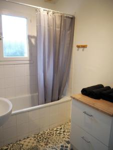 a bathroom with a tub and a sink and a shower at Chez Léonie in Sainte-Mère-Église +12 photos