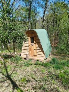 a wooden out house with a green roof at Roulotte et Cabane Par Hasard in Saint-Bressou