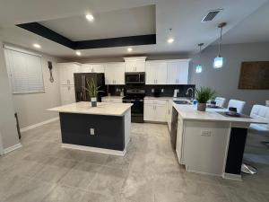 a large kitchen with white cabinets and black appliances at 2 Bedrooms Apartment in Storey Lake in Kissimmee