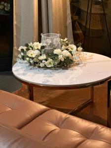 a table with a bouquet of flowers on it at Brown Deer - z Sauną na Tarasie, Jacuzzi i Widokiem na Góry - by Deer Hills Luxury Apartments in Kocoń
