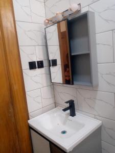 un bagno con lavandino e specchio di JAMOS House a Kigali Altre 5 foto
