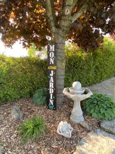 a garden with a sign in front of a tree at MonJardin Bed and Breakfast in Port Burwell