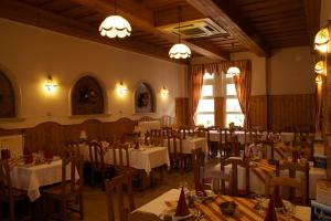 a dining room with tables and chairs and lights at Gerendas Panzió in Szombathely