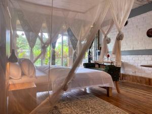 a bedroom with a canopy bed and a desk at Mount Kilimanjaro 360 view Cottage in Uru