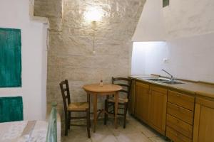 a kitchen with a table and chairs and a sink at Dimora d Artista in Terlizzi
