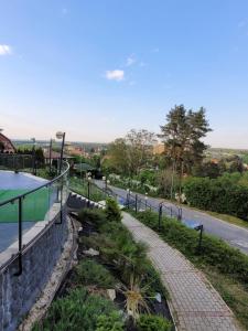 a brick walkway next to a road with a pool at Panorama Hill in Szombathely