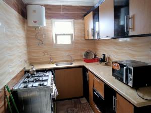 a small kitchen with a stove and a microwave at شاليه ديمورا عائلات فقط Dimora Chalet Only Family in Dawwār Muḩammad Abū Shunaynah