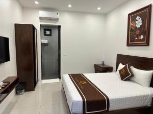 a hotel room with a bed and a television at Tam Coc Morning Homestay & Spa Ninh Binh in Vũ Lâm