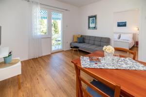 a living room with a table and a couch at Seaside Apartments Pinezic in Malinska