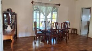 een eetkamer met een tafel en stoelen en een raam bij Casa em Aguas de Lindoia - Próxima ao balneário e da praça principal in Águas de Lindóia