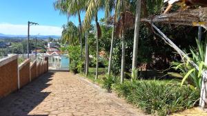 een stoep met palmbomen aan de zijkant van een huis bij Casa em Aguas de Lindoia - Próxima ao balneário e da praça principal in Águas de Lindóia