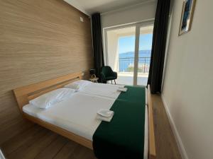 ポヴィレにあるApartmány Kamelias 3 minúty pešo od moraのベッドルーム1室(ベッド1台、窓、椅子付)