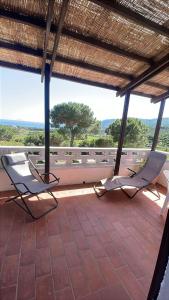 two chairs sitting on a porch with a view at Villa Conti Residence in Lacona +6 photos