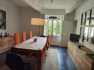 a dining room with a wooden table and chairs at Bastide du château in Montfaucon
