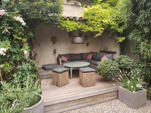 a patio with a couch and a table in a garden at Bastide du château in Montfaucon