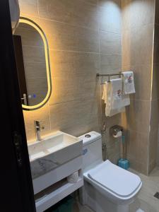 a bathroom with a toilet and a sink and a mirror at Debolonia Palace Hotel in Douala +24 photos