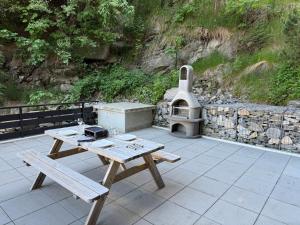 a picnic table with a grill on a patio at Nendaz Nest - Appartement moderne & confortable au cœur de Nendaz - 4 Vallées in Nendaz +34 photos