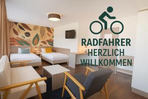 un soggiorno con un cartello con la scritta "bicicletta" sul muro di Hotel Madeleine Biohotel a Saarbrücken