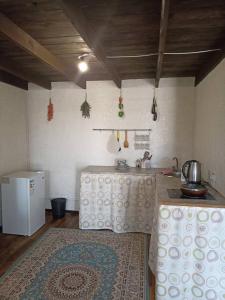 a room with a kitchen with a table and a rug at Пансионат Абрикос in Dolinka