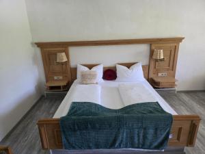 a bedroom with a large white bed with two lamps at FeWo Allgäu Natur Spa in Wiggensbach +9 photos