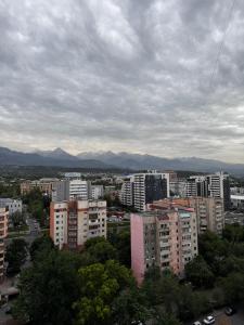a view of a city with buildings and mountains at Samal deluxe in Almaty