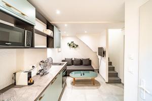 Una cocina y una sala de estar con un sofá y una mesa. en Cocon moderne Émile Zola, en Villeurbanne