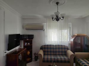 a living room with a chair and a television at Huzurlu Triplex Villa in Bozyazı +26 photos