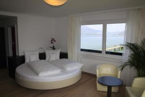 a bedroom with a bed and a large window at Seehotel Lilly in Strobl
