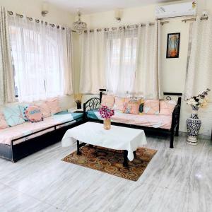 a living room with two couches and a table at Villa De Quads in Lonavala