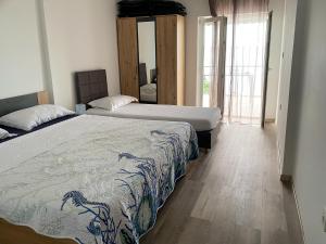 a bedroom with two beds and a large window at Beach Apartments Luka in Tribanj-Krušćica