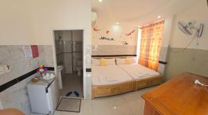 a small bedroom with a bed and a shower at Hoang Chau Motel in Vung Tau