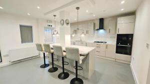 a white kitchen with a table and chairs at 5BDR Spacious En-suite Accomodation in Coventry +19 photos