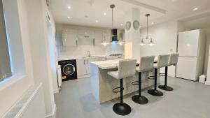 a kitchen with a bar with stools and a counter at 5BDR Spacious En-suite Accomodation in Coventry