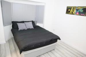 a bedroom with a bed with a black comforter at 5BDR Spacious En-suite Accomodation in Coventry