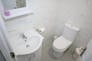 a white bathroom with a toilet and a sink at 5BDR Spacious En-suite Accomodation in Coventry