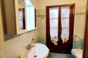 a bathroom with a sink and a toilet and a mirror at Al porto in Àrbatax +8 photos