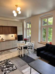 sala de estar con mesa y sofá negro en Dworskiego 74 Apartament 5, en Przemyśl