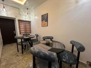 una sala de espera con dos mesas y taburetes en Grand Lynks Homes and Apartments, en Gwarinpa