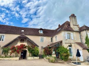 Une vieille maison avec des fleurs à l'avant dans l'établissement Domaine Borgnat, à Escolives-Sainte-Camille