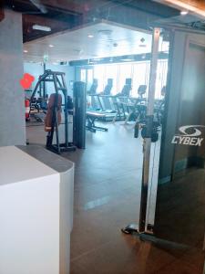 une salle de sport avec des rames de tapis roulants et des machines dans l'établissement Mayan Buildings studio with private beach, à Abu Dhabi