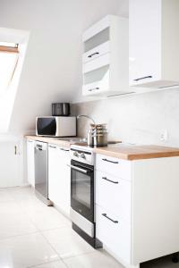 a kitchen with white cabinets and a stove top oven at Turkus in Międzywodzie