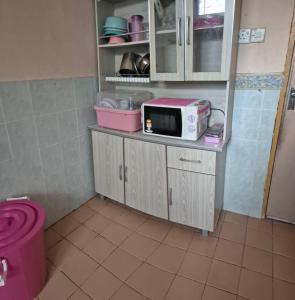 a kitchen with a microwave on top of a counter at Yanzz Homestay in Kampong Sorosob