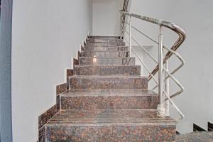 a set of stairs with a metal railing at Collection O Petals Otium Business Hotel in Bengaluru